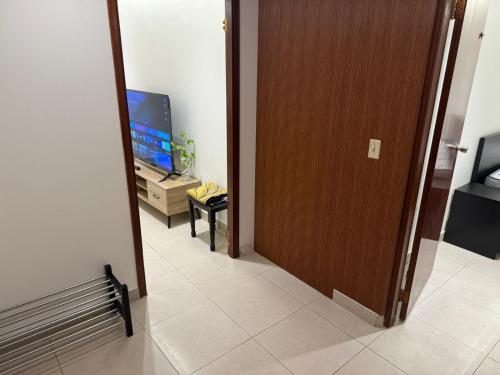 una porta che conduce a una camera con televisore e corridoio di Elegant Studio a Al Fanātīr