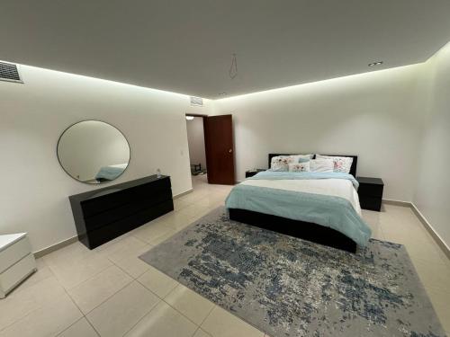 - une chambre avec un grand lit et un miroir dans l'établissement Elegant Studio, à Al Fanātīr