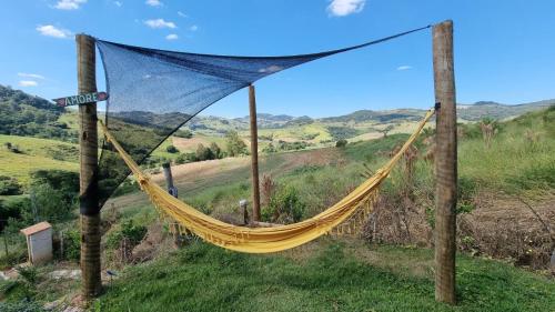 a hammock hanging from two wooden poles in a field at REFUGIO PIEMONTE Chalés in Socorro