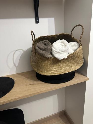 a basket of towels sitting on a shelf at Le coup de c’Heurt duplex 100m de la mer 8 personnes in Le Portel