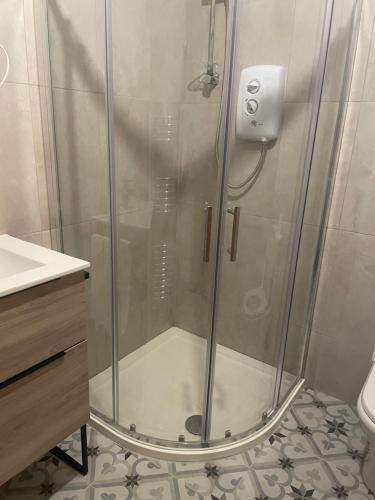 een douche met een glazen deur in de badkamer bij Wards in Ballina