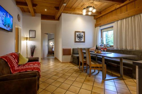 ein Esszimmer und ein Wohnzimmer mit einem Tisch und Stühlen in der Unterkunft Restaurant Appartements Almdiele in Hart im Zillertal
