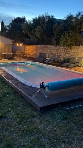a swimming pool at night with chairs around it at Villa provençale - piscine-calme in Draguignan