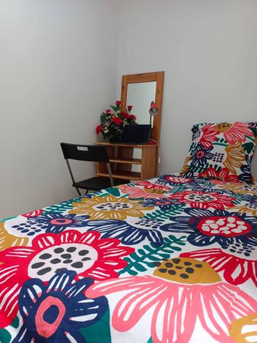 une chambre avec un lit avec une couette colorée dans l'établissement Mini Studio au calme, à Colombes