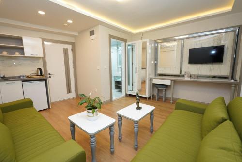 a living room with a green couch and a kitchen at gazelle suites in Istanbul