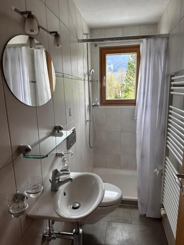 a white bathroom with a sink and a shower at Ferienwohnung Crameri in Klosters