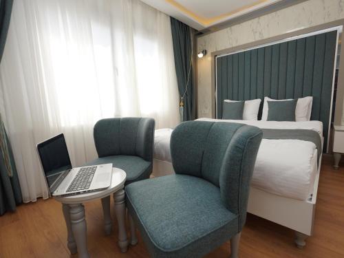 a hotel room with a bed and a laptop on a table at gazelle suites in Istanbul