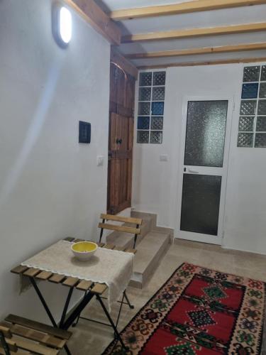 a living room with a table and a window and stairs at Villa Olive Old Qeparo in Qeparo