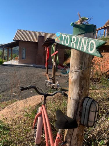 a bike parked next to a street sign on a pole at REFUGIO PIEMONTE Chalés in Socorro