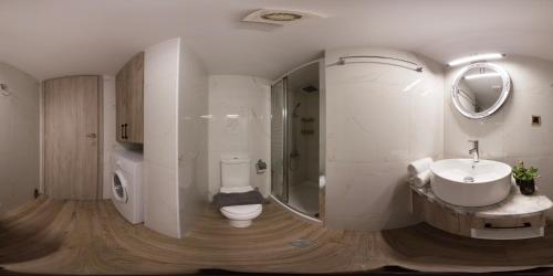 a white bathroom with a toilet and a sink at 7thHeaven Luxury aprts in Chania Town
