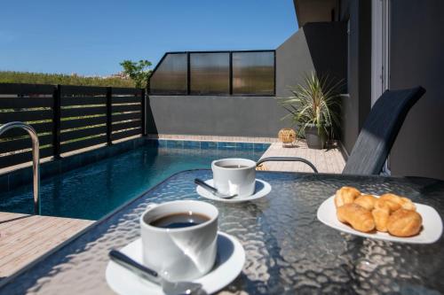 a table with two cups of coffee and pastries on it at 7thHeaven Luxury aprts in Chania Town