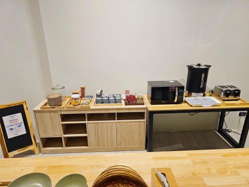 a kitchen with a stove and a microwave on a counter at The Way Hotel Ban Pong in Ban Pak Raet