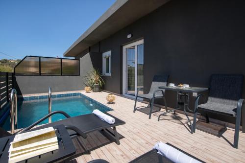 a patio with a pool and chairs and a table at 7thHeaven Luxury aprts in Chania Town