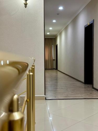 um corredor com um lavatório e uma porta num quarto em RoyalandCozy em Nukus