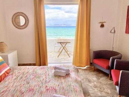 a bedroom with a bed and a view of the ocean at The Beachhouse Apartments in Vaia