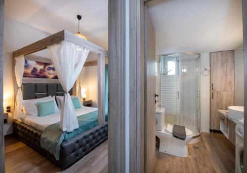 a bedroom with a canopy bed and a bathroom at 7thHeaven Luxury aprts in Chania Town