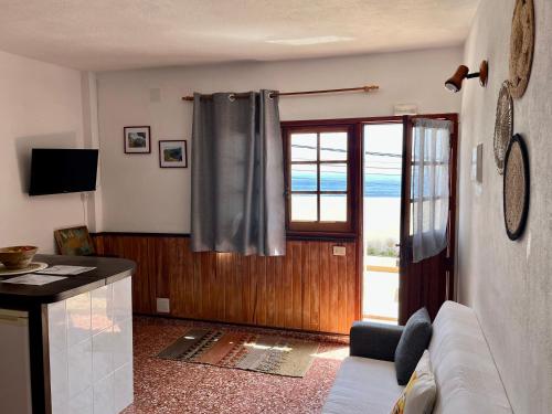 Casa Los Palitos في Monte de Breña: غرفة معيشة مع أريكة ونافذة
