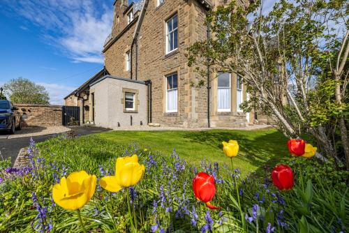 uma casa com flores no quintal da frente em Lower Tweedknowe - ground floor villa Melrose em Melrose