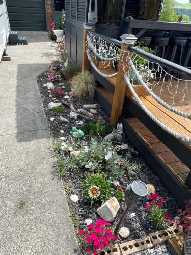 a garden with a hammock and flowers in front of a house at Mels Retreat in Te Kuiti