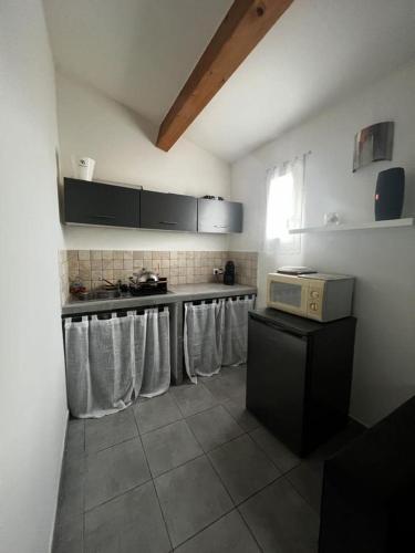 - une cuisine équipée d'une cuisinière et d'un comptoir avec des serviettes dans l'établissement Studio avec jardin privatif, à Porto-Vecchio