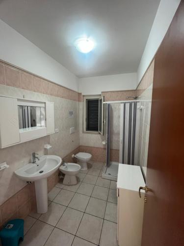 a bathroom with two toilets and a shower and a sink at Villa Angela case vacanza in Vieste