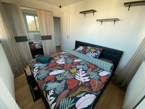 een slaapkamer met een bed met een kleurrijk dekbed bij Appartement - Nanterre in Nanterre