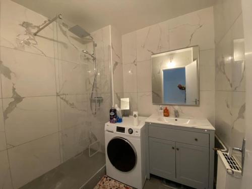 een badkamer met een wasmachine en een wastafel bij Appartement - Nanterre in Nanterre