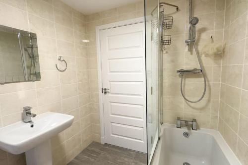 a bathroom with a shower and a sink and a tub at 4 Bed complete Home in Edinburgh Near Airport in Edinburgh