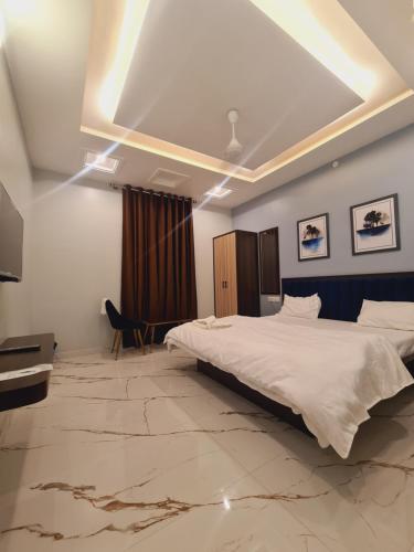 een hotelkamer met een bed en een televisie bij Hotel Kaanjee in Sīkar