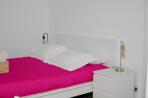 a bed with red sheets and white pillows at Casa Vila Rosa in Peso da Régua