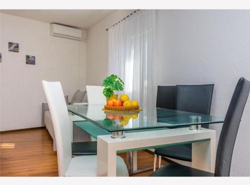 a glass dining room table with a bowl of fruit on it at Apartments Vulić in Omiš