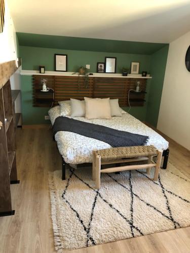 Un dormitorio con una cama y una pared verde. en Au Dessus De Chez Nous, en Doulezon