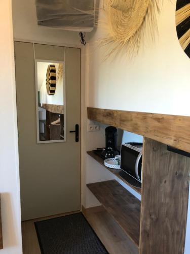 - une cuisine avec une porte en bois et un four micro-ondes dans l'établissement Au Dessus De Chez Nous, à Doulezon