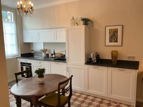 une cuisine avec une table en bois et une table et des chaises dans l'établissement Au cœur d'Avignon - Logement climatisé, à Avignon