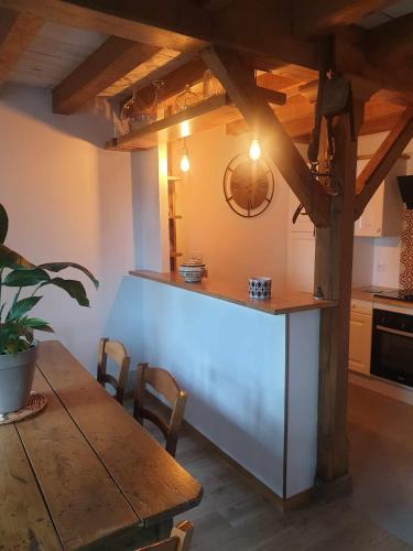 une cuisine avec une table en bois, une table et un comptoir dans l'établissement Gite Ar HI MEN, à Malansac