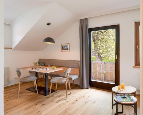 a dining room with a table and chairs and a window at Ferienhof Neusacher Moser in Weissensee