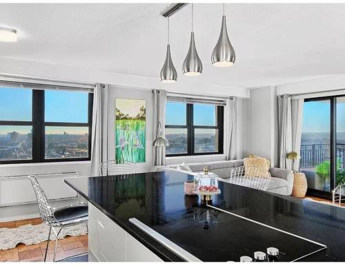 a kitchen with a black counter top in a room with windows at Manhattan skyline under your feet in North Bergen