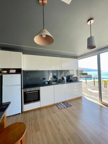 a kitchen with white cabinets and a view of the ocean at Casa do mar in São Vicente