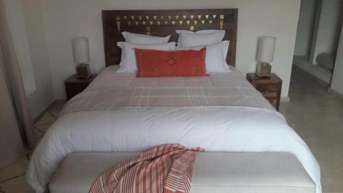 a large bed with red pillows in a bedroom at Villa Magnolia - Amelkis Golf in Marrakech