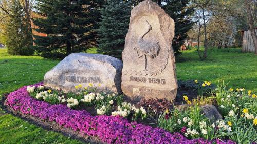a stone statue in a garden with flowers at Crow's nest in Grobiņa