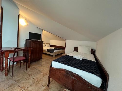 a bedroom with a bed and a desk and a television at Beatrix Lux Hotel in Budva