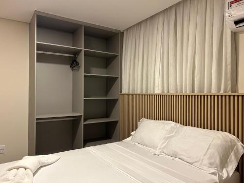 ein Schlafzimmer mit einem Bett und einem Bücherregal in der Unterkunft Loft Solaris Apart Hotel - Suíte - Apt N102 in João Câmara