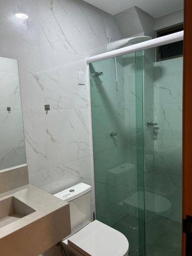 ein Bad mit einer Glasdusche und einem WC in der Unterkunft Loft Solaris Apart Hotel - Suíte - Apt N102 in João Câmara