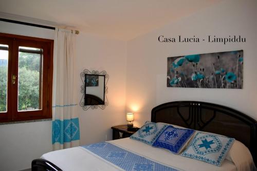 ブドーニにあるCasa Luciaのベッドルーム1室(青い枕のベッド1台、窓付)