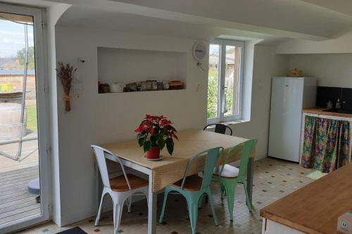 - une cuisine avec une table et une plante en pot dans l'établissement Le Vingt-Six, à Rochefort-sur-Loire