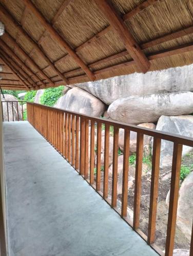 a wooden walkway in front of a rock wall at Joma Adventure Lodge in Senga