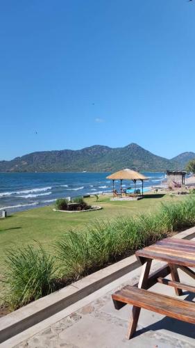 a picnic table next to a beach with the ocean at Joma Adventure Lodge in Senga