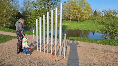 a woman and a child standing next to a fence at Crow's nest in Grobiņa
