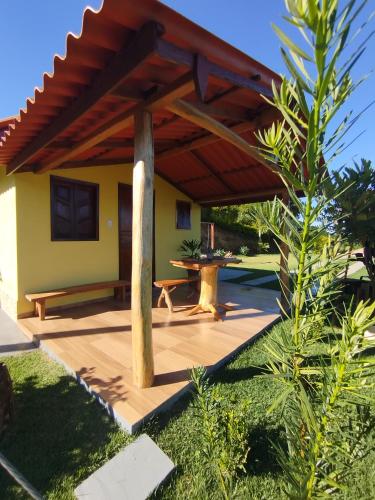 a patio with a table under a roof at Chalé Pingo de Ouro in Alto Caparao