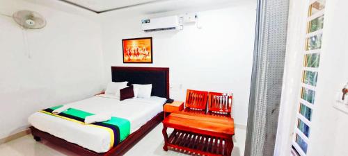 1 dormitorio con 1 cama y 1 silla en Coorg Dew Drops Resort, en Kushālnagar